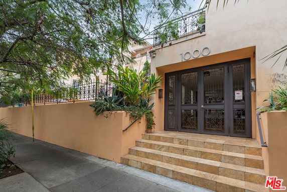 Front view of a building with steps leading to a wrought iron door entrance.