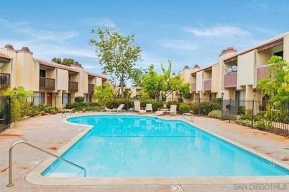 Outdoor swimming pool with surrounding apartment buildings.