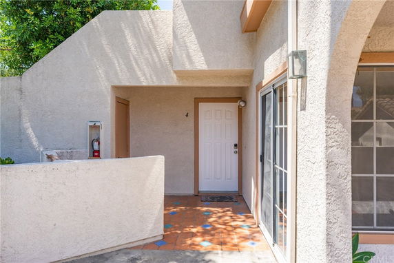 Front view of a house with a single entry door and adjacent window.