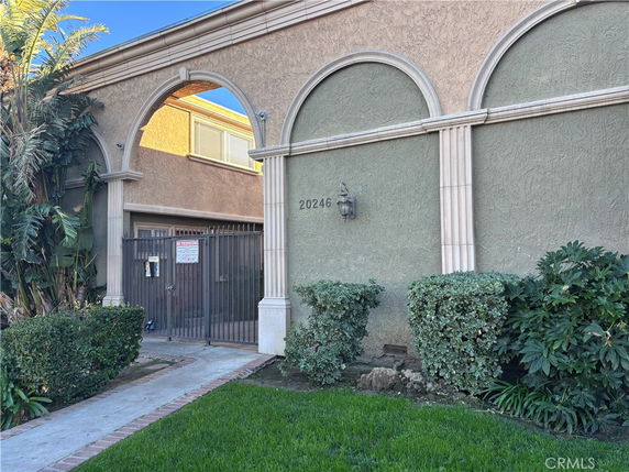 Front view of a building with arched designs and a gated entrance.