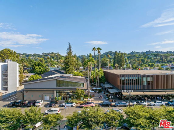 Front view of commercial buildings with large glass windows and parking area in front.