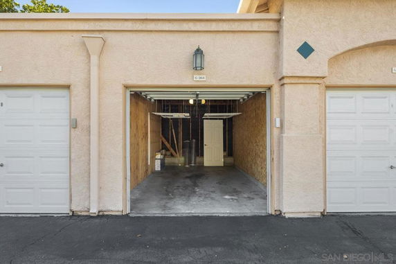Open garage with beige walls and a concrete floor.