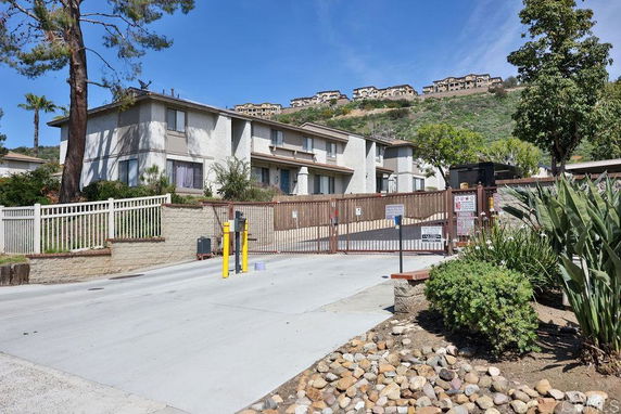 Front view of a two-story residential building with gated entrance.