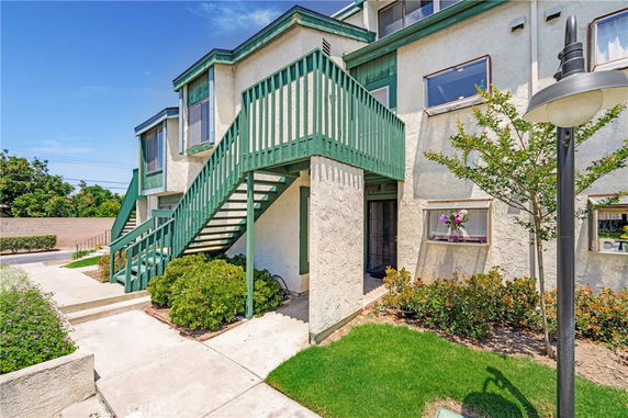 Front view of a two-story building with green exterior stairs.