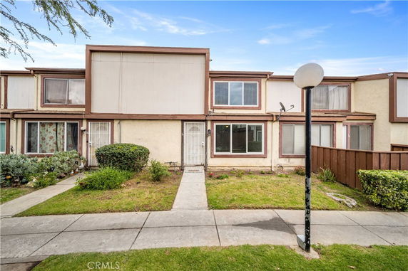 Front view of a two-story townhouse with a small front yard and sidewalk.