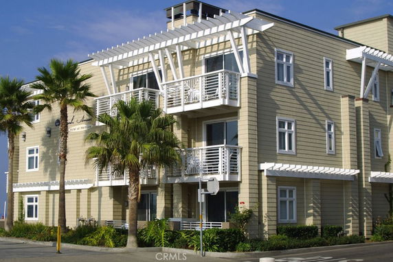 Front view of a multi-story building with balconies and white trim.