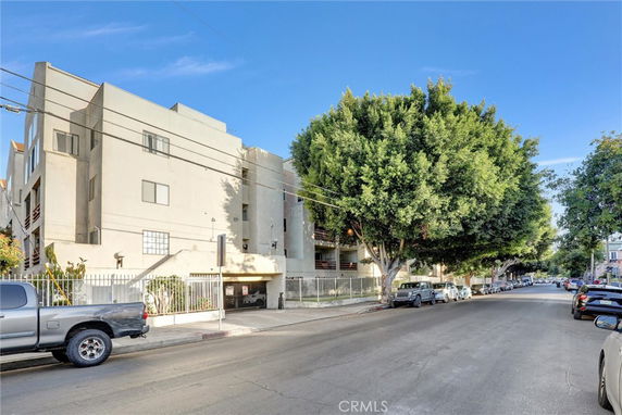 Front view of a multi-story apartment building on a street.