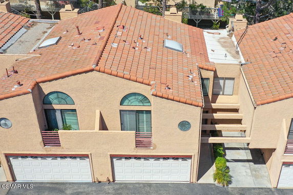 Front view of a multi-story building with arched windows and double garage doors.