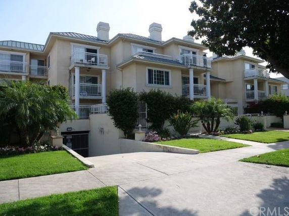 Front view of a multi-story building with balconies and chimneys.