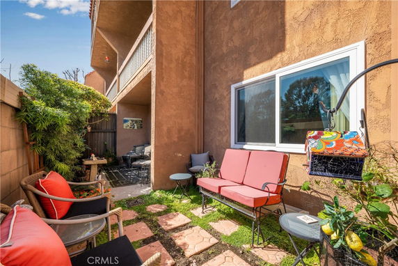 Outdoor seating area adjacent to a building with patio chairs and tables.