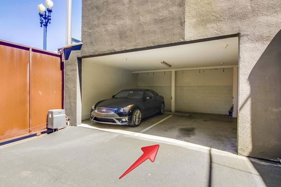 Covered outdoor parking area with a single car parked inside.