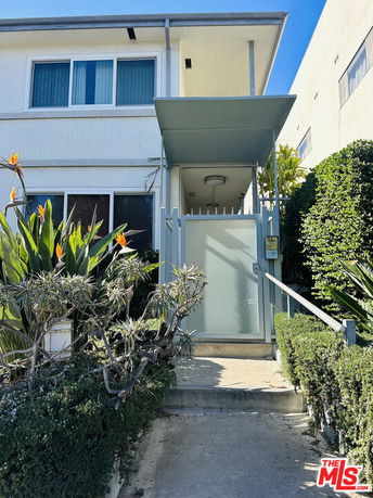 Front view of a two-story building with a gated entrance.