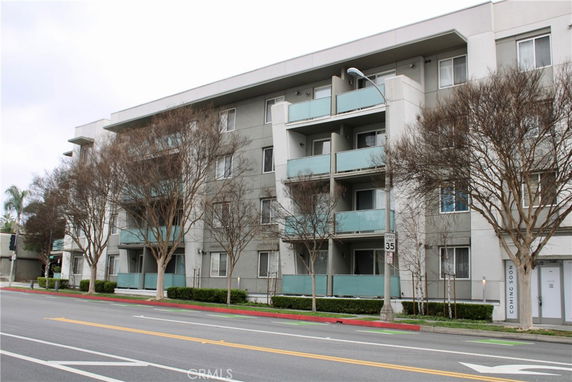 Front view of a multi-story residential building with balconies and a modern facade.