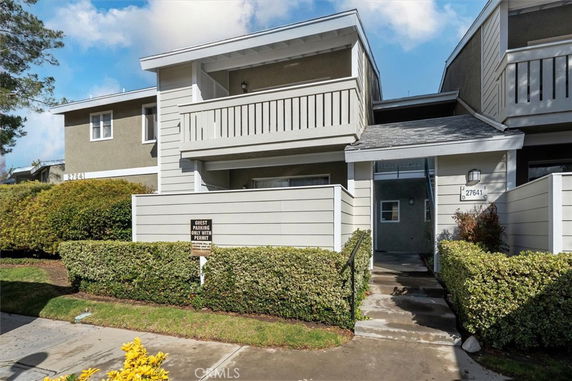 Front view of a two-story townhouse with a balcony and entrance walkway.