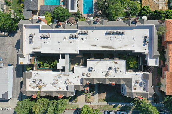 Top view of a building with white rooftop featuring air conditioning units.