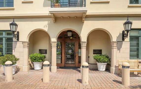 Front view of a building with arched entrances and exterior lighting.