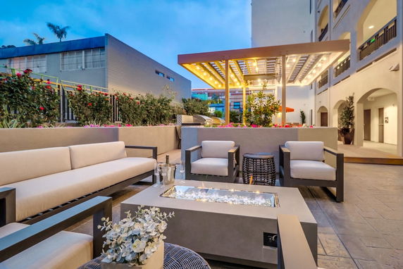 Outdoor seating area with modern furniture and a covered canopy with lights.