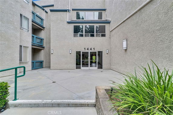 Front view of a multi-story building with balconies and a central entrance.