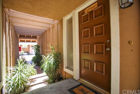 Front entrance view of a house with a welcoming door and covered walkway.