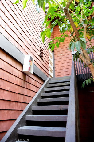 Exterior view of a building with wooden staircase leading to the entrance.
