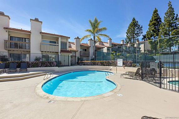Outdoor swimming pool area with adjacent residential buildings.