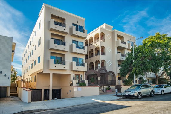 Front view of a multi-story apartment building with balconies.