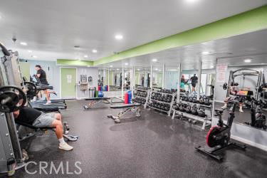 Interior view of a gym with exercise equipment and mirrored walls.