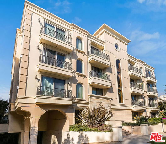 Front view of a modern multi-story apartment building with balconies.