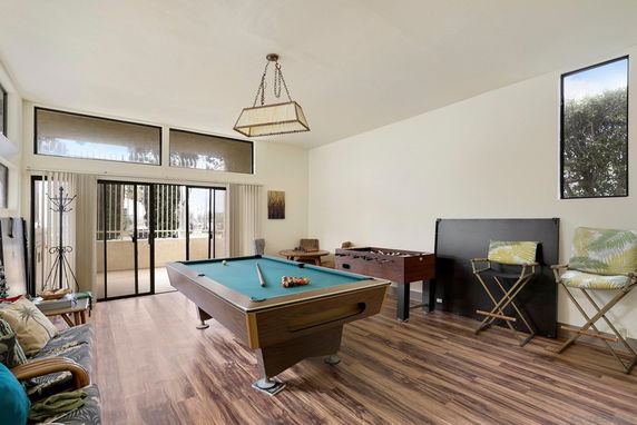 Room with a pool table and foosball table.