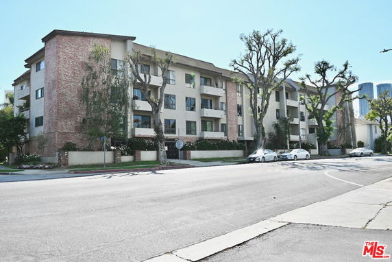 Front view of a multi-story apartment building with a mix of brick and stucco exterior.