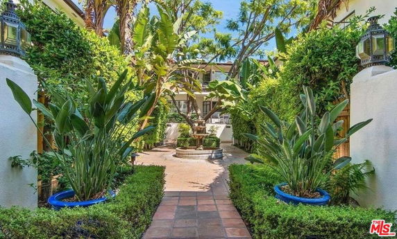 Front view of a house with a lush garden and pathway.