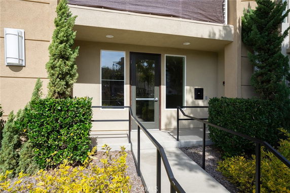 Front view of a building entrance with a glass door and two side windows.