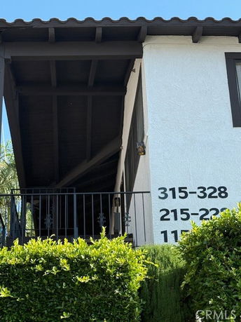 Front view of a building with numbers on the wall and a dark-colored roof.
