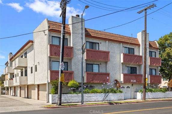 Front view of a multi-story apartment building with balconies.
