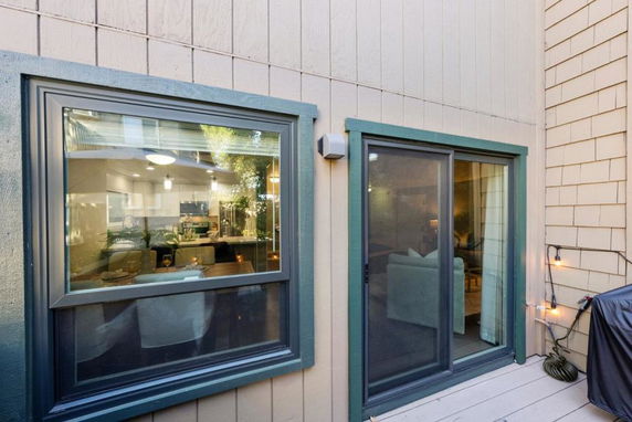 Exterior view showing a window and sliding glass door of a house.