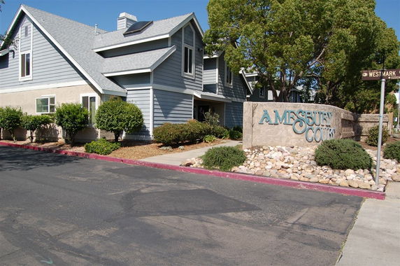Front view of a multi-story house with grey siding and a sloped roof.