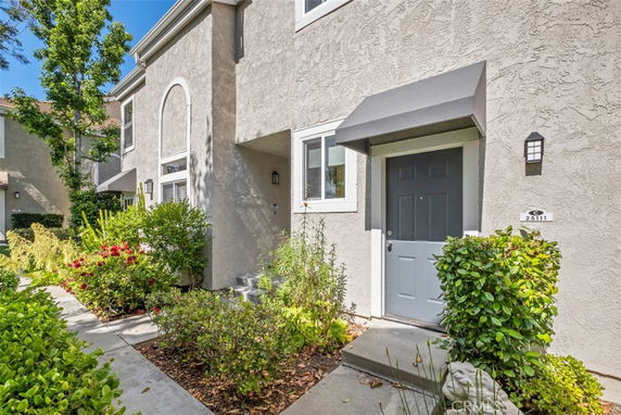 Front view of a two-story house with a gray door and arched window.
