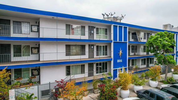 Front view of a three-story apartment building with blue and white exterior.