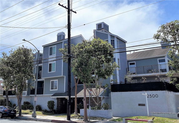 Front view of a multi-story residential building with balconies and a blue exterior.