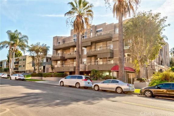 Front view of a multi-story apartment building with balconies.
