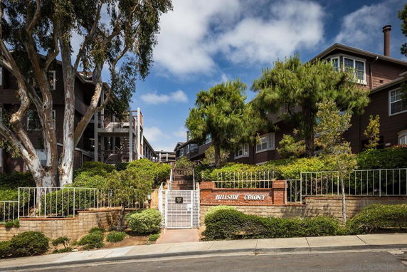 Front view of a multi-story residential complex with a gated entrance.