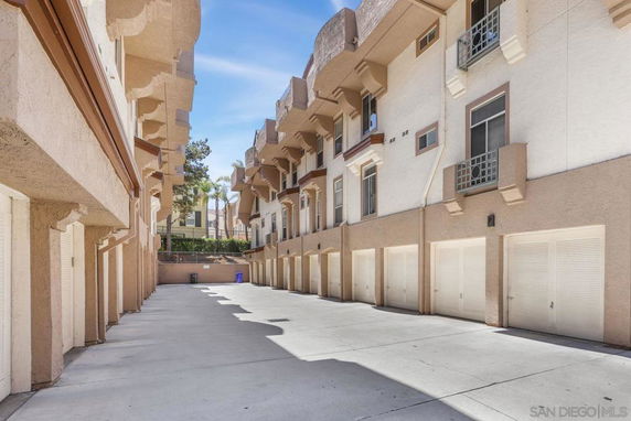 Outdoor parking area of a building with multiple garage doors.