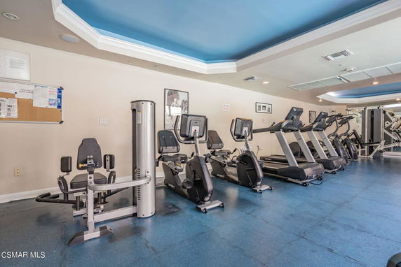 Room with gym equipment including treadmills and exercise machines.