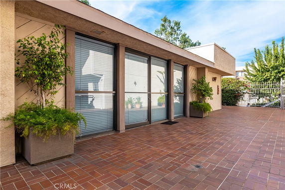 Front view of a building with large windows and potted plants.