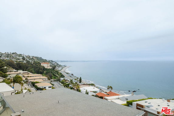 Wide-angle view of a coastal area with ocean and hillside residences.