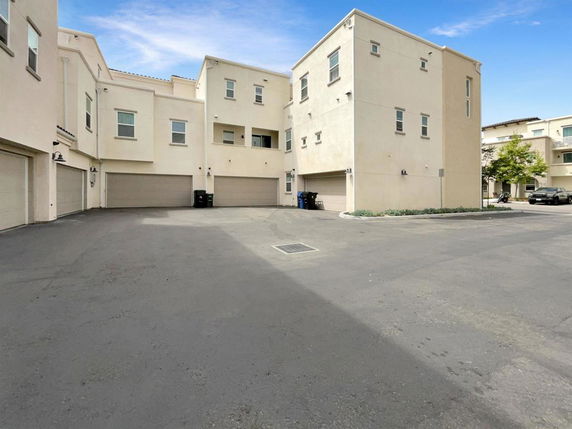 Outdoor parking area in front of multi-story residential buildings.