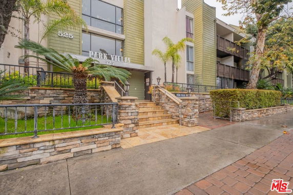 Front view of a multi-story building with stone steps and railings leading to an entrance marked as Park Villas.