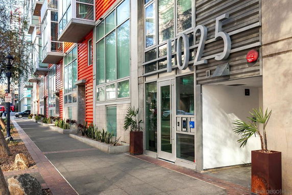 Front view of a modern multi-story building with large windows and balconies.