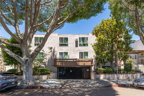 Front view of a multi-story residential building with a gated entry.