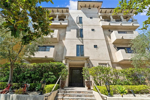 Front view of a multi-story apartment building with balconies.